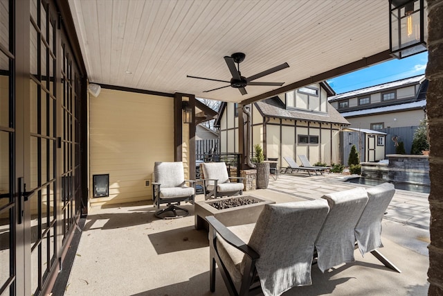 view of patio with ceiling fan, an outdoor fire pit, and a shed