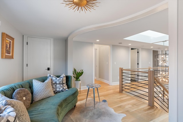 living room featuring a skylight and light wood-type flooring