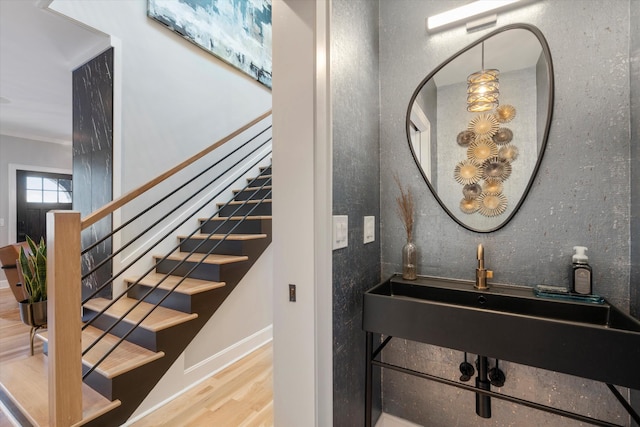 stairway featuring hardwood / wood-style floors and sink