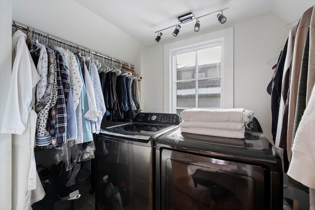 laundry area with rail lighting and independent washer and dryer