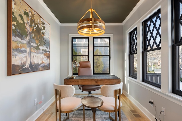 home office featuring an inviting chandelier, ornamental molding, and light hardwood / wood-style floors