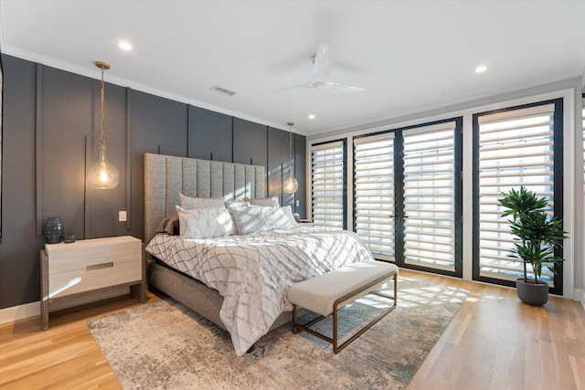 bedroom featuring crown molding, ceiling fan, and light hardwood / wood-style flooring