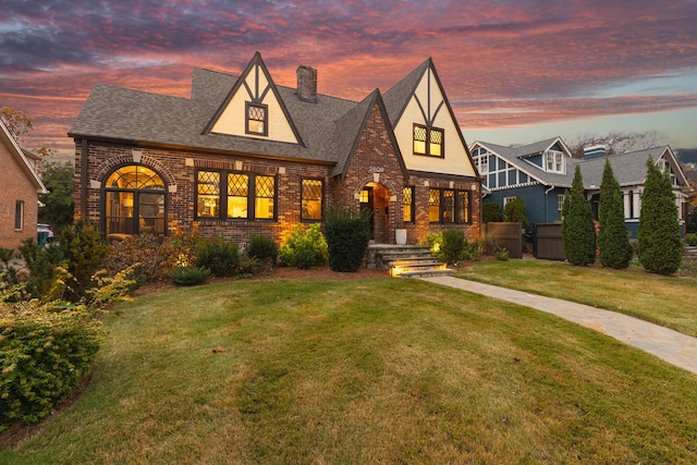 tudor-style house featuring a lawn