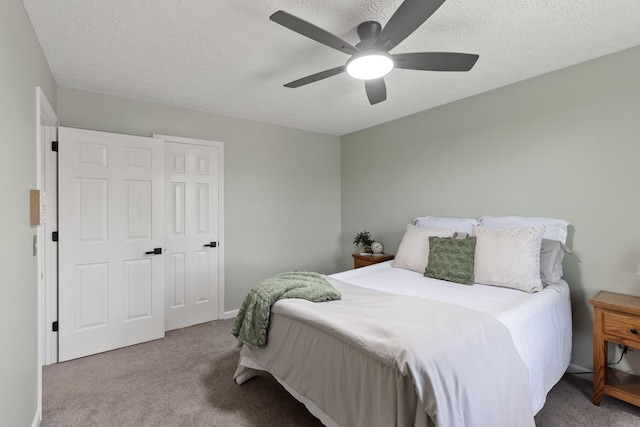 carpeted bedroom with ceiling fan and a textured ceiling