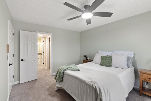 carpeted bedroom featuring ceiling fan and a textured ceiling