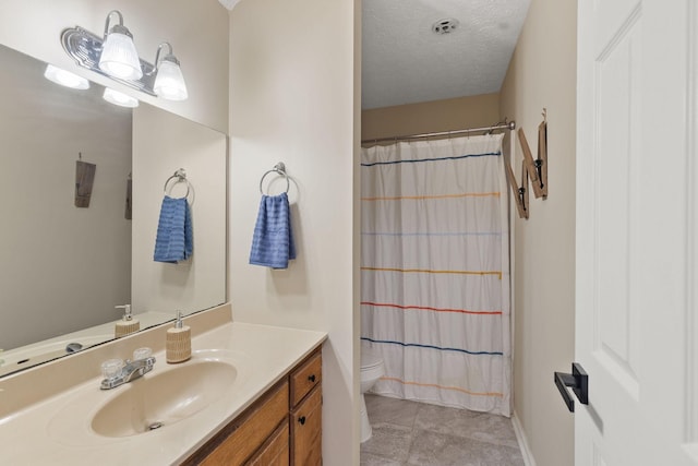 bathroom with vanity, a textured ceiling, and toilet