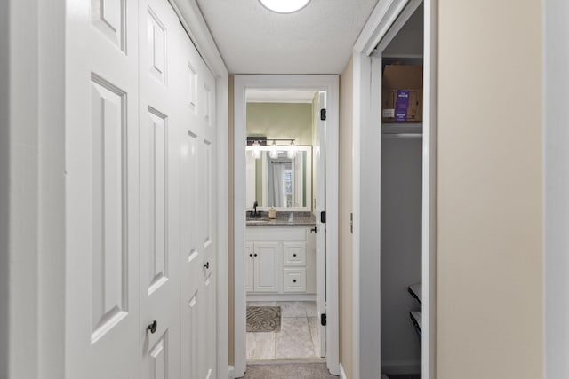 hall featuring sink and a textured ceiling