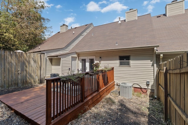 rear view of house with central AC unit, a deck, and french doors