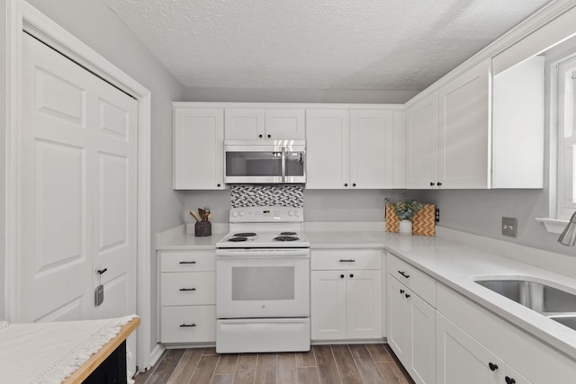 kitchen featuring electric stove, sink, light hardwood / wood-style flooring, a textured ceiling, and white cabinets