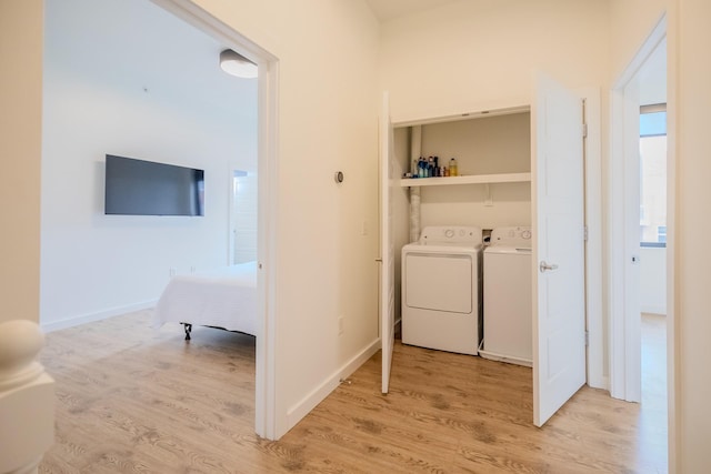 laundry room featuring washing machine and dryer and light wood-type flooring