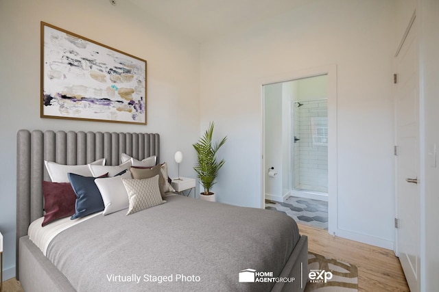 bedroom with ensuite bath and light wood-type flooring