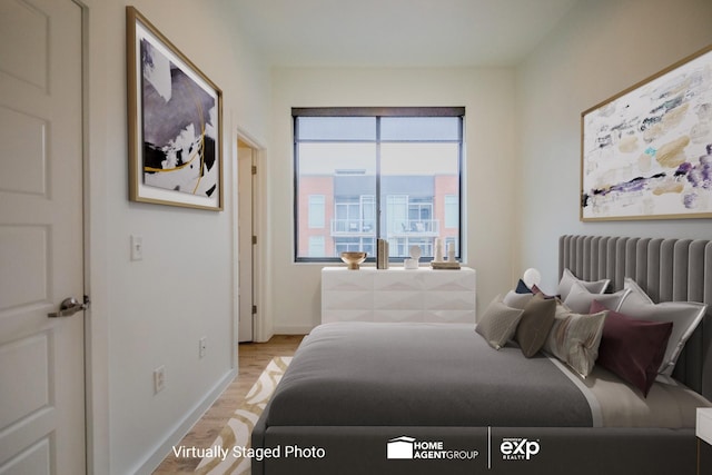 bedroom with radiator heating unit and light hardwood / wood-style floors