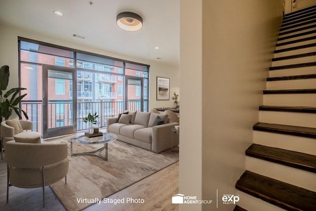 living room with floor to ceiling windows and light hardwood / wood-style floors