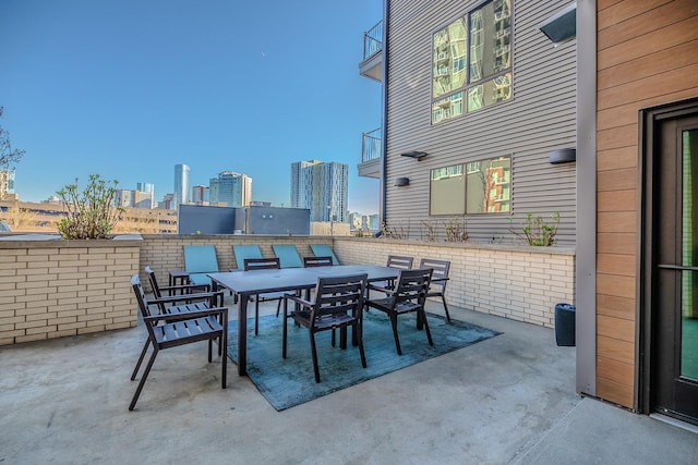 view of patio / terrace with outdoor dining area and a city view