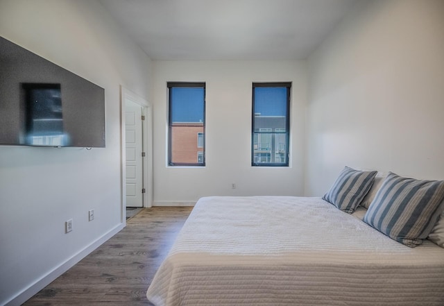 bedroom featuring baseboards and wood finished floors