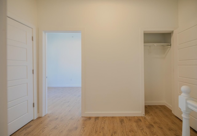 interior space featuring light wood-style flooring, baseboards, and a closet