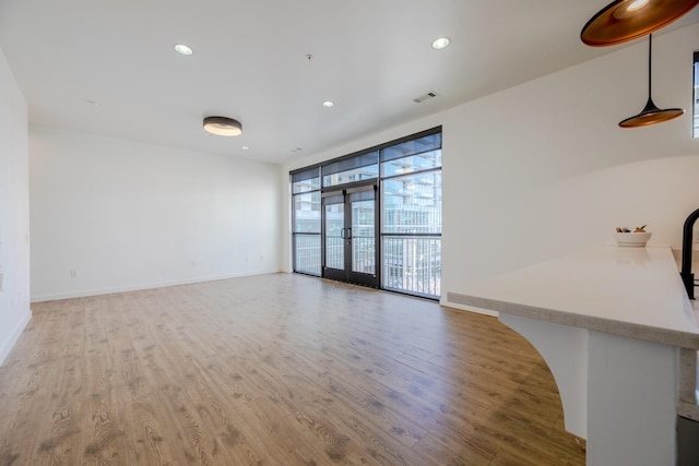 unfurnished living room featuring recessed lighting, baseboards, visible vents, and wood finished floors