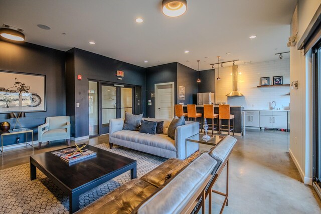 living area featuring visible vents, baseboards, concrete floors, rail lighting, and recessed lighting