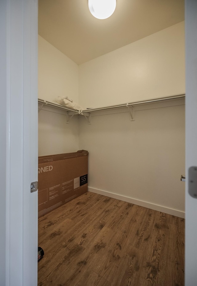 walk in closet with wood finished floors