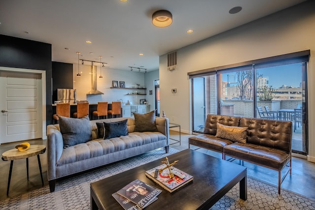 living area with baseboards, track lighting, and recessed lighting