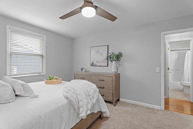 carpeted bedroom with ceiling fan and ensuite bath