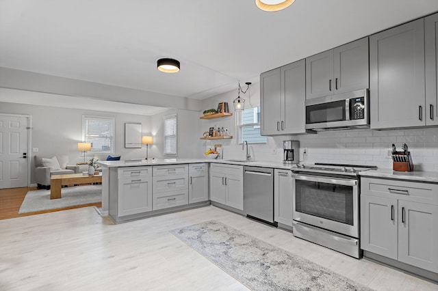 kitchen with gray cabinetry, sink, and stainless steel appliances