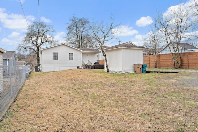 rear view of property with a yard and cooling unit