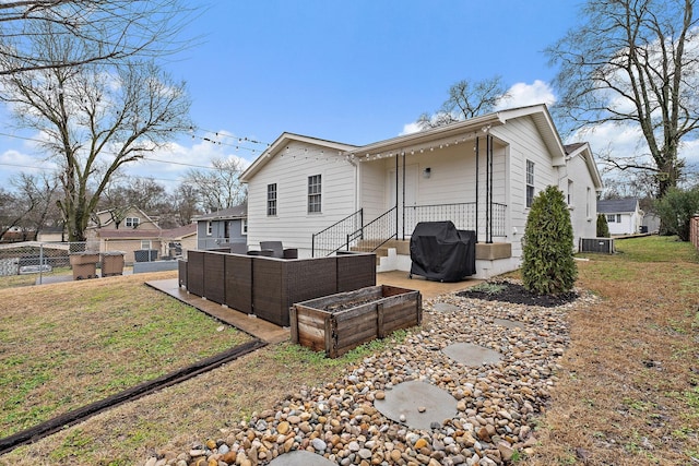 rear view of property with an outdoor hangout area and a yard