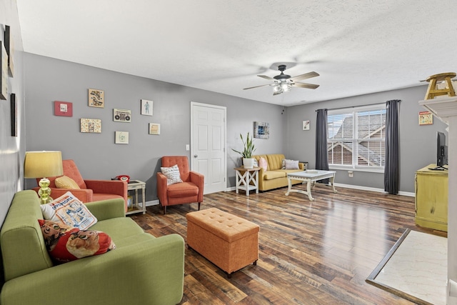 living room with ceiling fan, dark hardwood / wood-style floors, and a textured ceiling