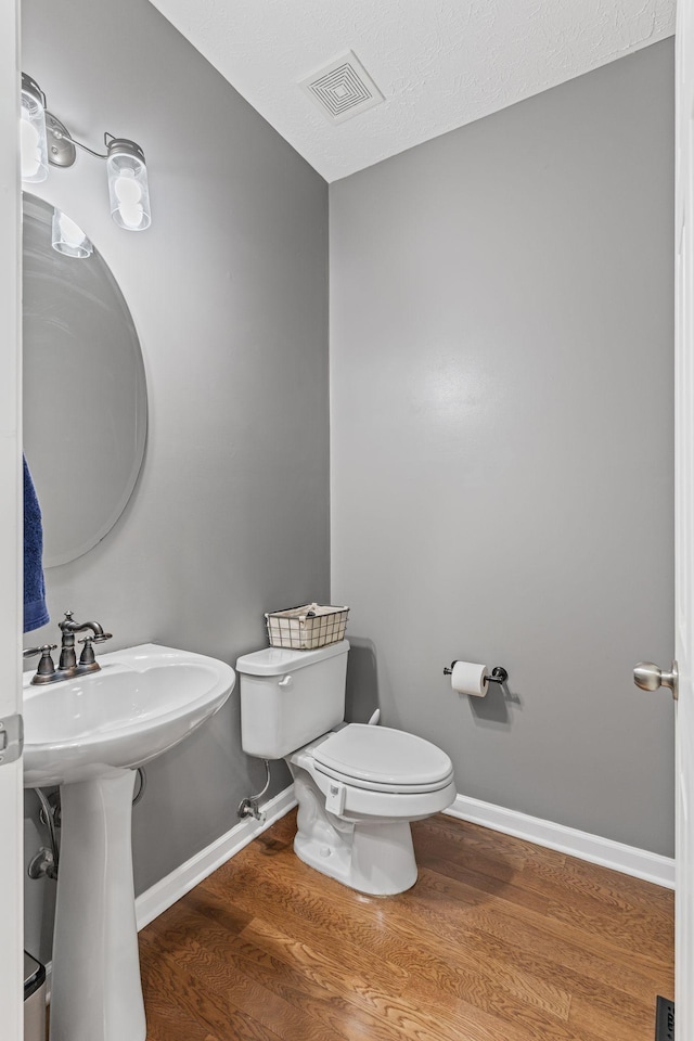 bathroom with sink, hardwood / wood-style floors, and toilet