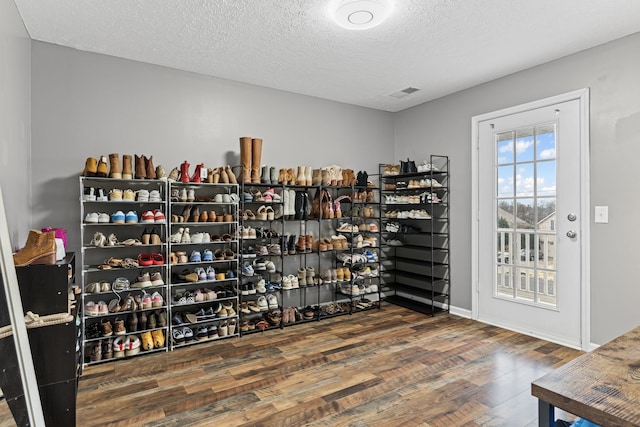 walk in closet with dark hardwood / wood-style flooring