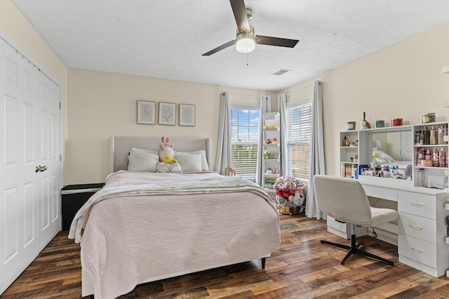 bedroom featuring a closet, a textured ceiling, dark hardwood / wood-style floors, and ceiling fan