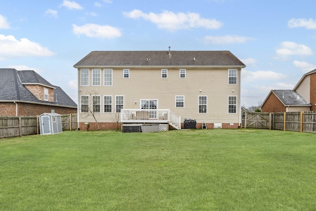 rear view of house with a lawn, a storage unit, and a deck