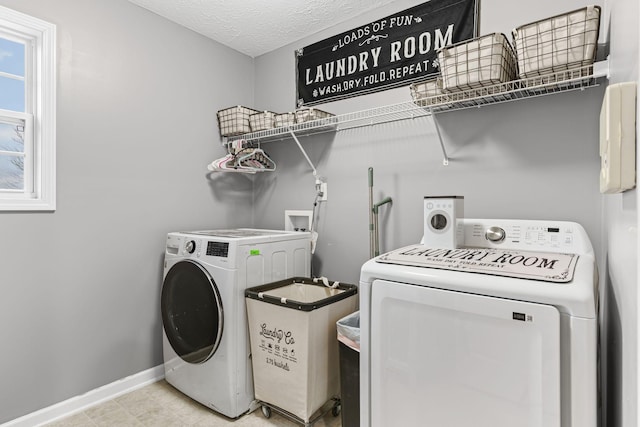 laundry room with a textured ceiling and independent washer and dryer