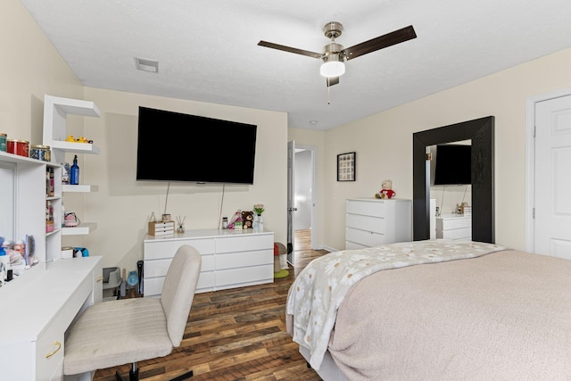 bedroom with ceiling fan, dark wood-type flooring, and a textured ceiling