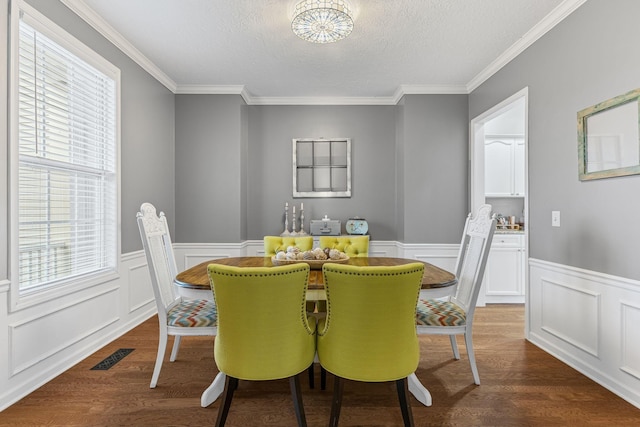 dining space featuring ornamental molding, dark hardwood / wood-style floors, and a textured ceiling