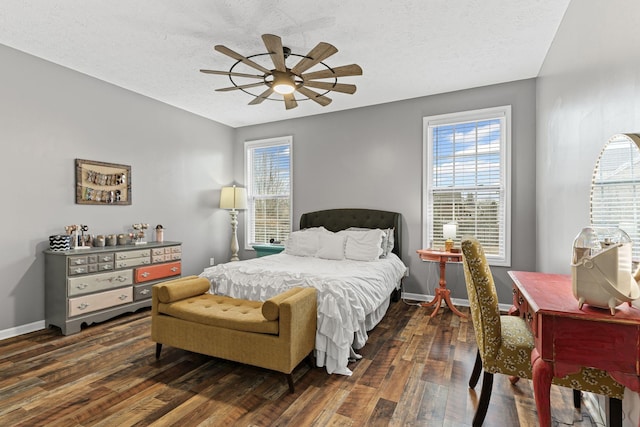 bedroom featuring dark hardwood / wood-style flooring, ceiling fan, and a textured ceiling