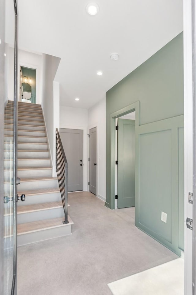 staircase featuring carpet