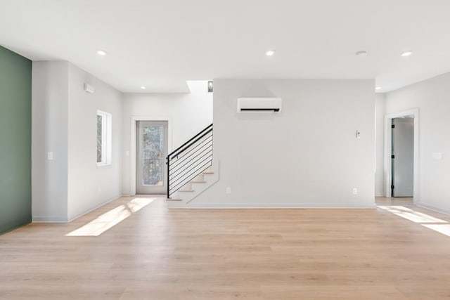 interior space with a wall unit AC and light wood-type flooring