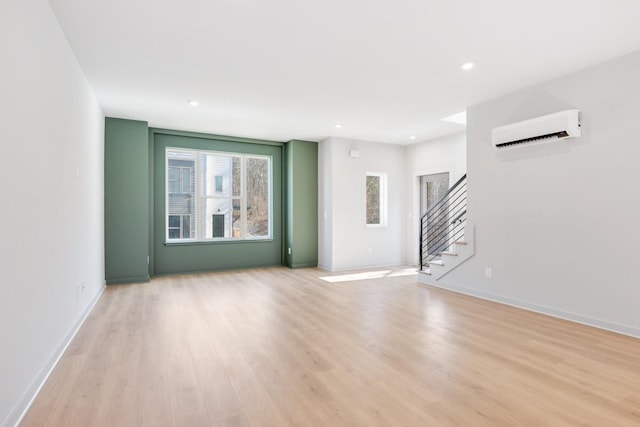 unfurnished room featuring light hardwood / wood-style floors and an AC wall unit