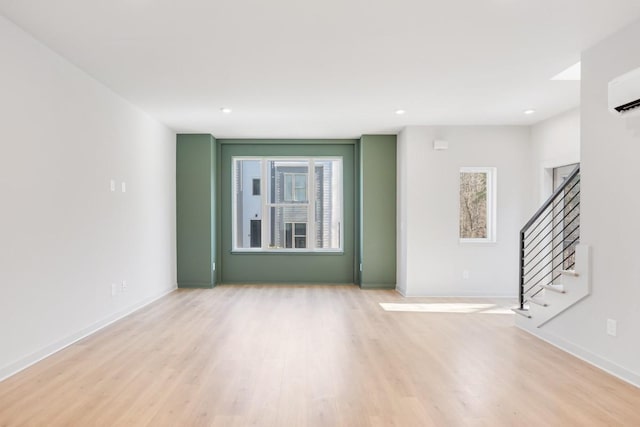 empty room featuring light hardwood / wood-style floors and an AC wall unit