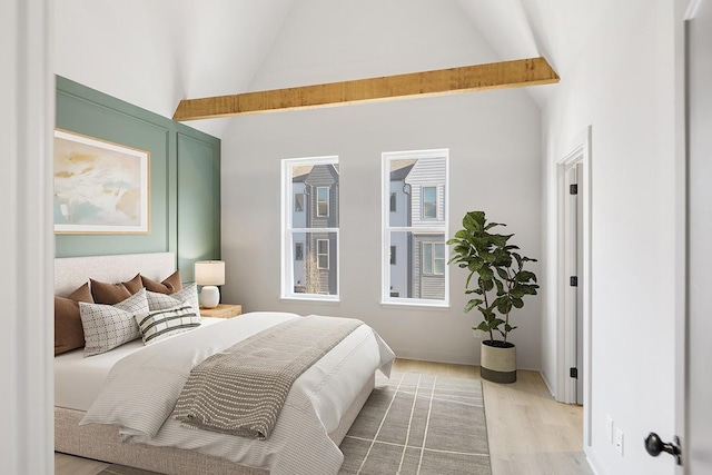 bedroom with beamed ceiling, high vaulted ceiling, and hardwood / wood-style floors