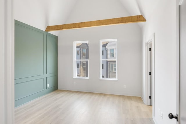 empty room with high vaulted ceiling, light hardwood / wood-style floors, and beamed ceiling