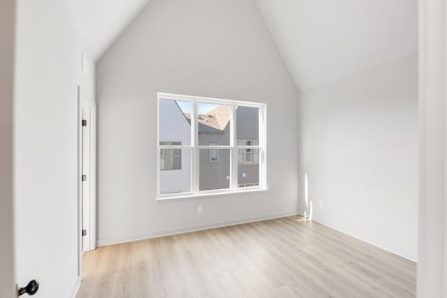 spare room featuring light hardwood / wood-style flooring and high vaulted ceiling