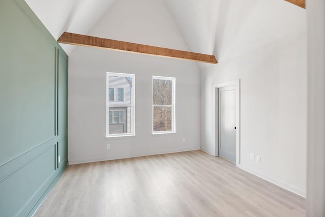 unfurnished room featuring beam ceiling, high vaulted ceiling, and light hardwood / wood-style flooring