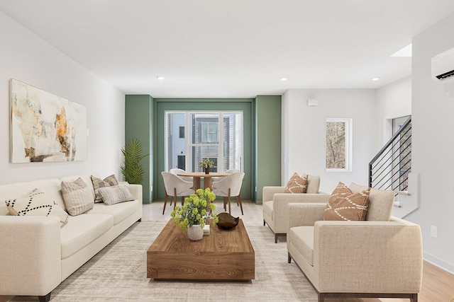 living room featuring an AC wall unit and light hardwood / wood-style flooring