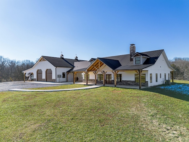 rear view of property with a garage and a yard