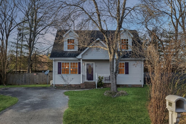 cape cod home with a front yard