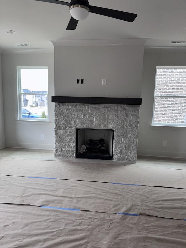 unfurnished living room with ceiling fan and ornamental molding