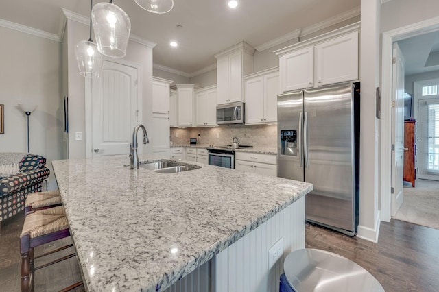 kitchen featuring stainless steel appliances, sink, white cabinets, and a spacious island